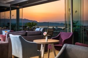 a room with a table and chairs and a sunset at Castello City Hotel in Heraklio