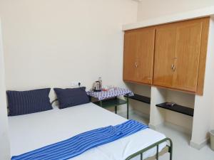 Un pat sau paturi într-o cameră la Sundaram Rooms