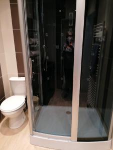 une personne prenant une photo d'une douche avec toilettes dans l'établissement Le repos chavagnais, à Chavagnes-en-Paillers