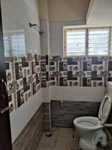 uma casa de banho com um WC e um chuveiro em Sundaram Rooms em Coimbatore
