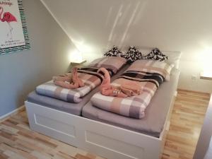 ein Schlafzimmer mit zwei Betten, die mit rosa Flamingos bedruckt sind in der Unterkunft Haus Valentin in Dornum