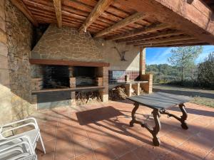 un patio con chimenea de piedra y mesa de picnic en Masia Catalana SolSenyor en Tarragona