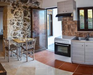 a kitchen with a table and a stove at Villa Irena panoramic sea view in Agalianós