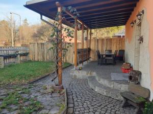 a patio with a wooden pergola with a table and a bench at Ferienhaus Victoria in Schwarzheide