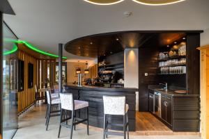 a bar with chairs and a counter in a restaurant at Hotel Fanes in Selva di Val Gardena