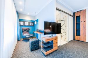 a room with a tv and a desk with a chair at Hochwald Lodge in Morbach