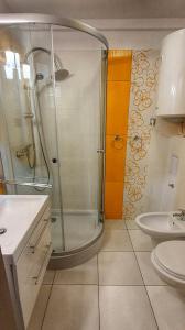 a bathroom with a shower and a toilet and a sink at Holiday Home SLAVIA NEW 11 in Międzyzdroje
