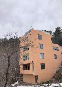 a building on top of a hill with trees at Paradise View Hotel & Restaurant in Khaira Gali