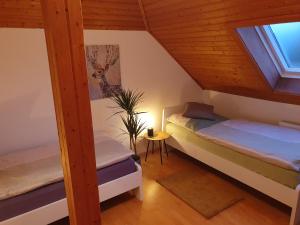 Zimmer im Dachgeschoss mit 2 Betten und einem Fenster in der Unterkunft Fewo Eifelhöhe in Kelberg