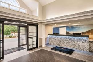a lobby with a reception desk and a large window at Baymont by Wyndham Henderson Oxford in Henderson