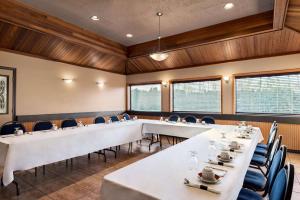 una sala de conferencias con mesas y sillas blancas en Travelodge by Wyndham Abbotsford Bakerview, en Abbotsford