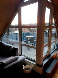 ein Wohnzimmer mit einem großen Fenster und einer Terrasse in der Unterkunft Fewo Eifelhöhe in Kelberg