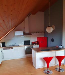 eine Küche mit weißen Schränken und einem roten Kühlschrank in der Unterkunft Fewo Eifelhöhe in Kelberg