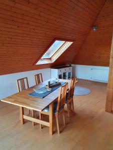 uma sala de jantar com uma mesa de madeira e uma clarabóia em Fewo Eifelhöhe em Kelberg