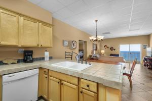 a kitchen with a sink and a living room at Sans Souci unit 706 in Pensacola Beach