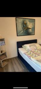 - une chambre avec un lit et une peinture murale dans l'établissement Plein Soleil 1, à Martigny-Ville