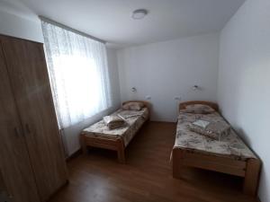 2 letti in una piccola camera con finestra di Vila Ljuti krš a Divčibare