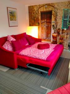 a red couch in a room with a bed at Entspanntes wohnen in Ostseenähe, gute Anbindung in Ratekau