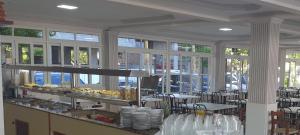a restaurant with tables and chairs and windows at Hotel Pousada Ilha do Mar Bombinhas in Bombinhas