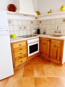 cocina con armarios de madera y horno de fogón blanco en Casa Ses Roques, en Ciutadella