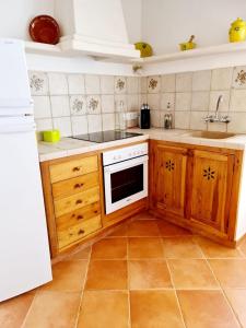 a kitchen with wooden cabinets and a white stove top oven at Casa Ses Roques in Ciutadella