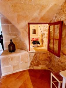 a room with a window and a vase on the floor at Casa Ses Roques in Ciutadella +23 photos