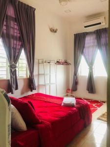 a red bed in a room with windows at Galleria Homestay Islamic Alor Setar in Alor Setar