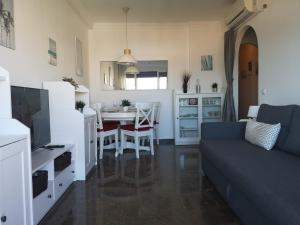APARTAMENTO 1ª LINEA PLAYA GARAJE PISCINAS TERRAZA في توريمولينوس: غرفة معيشة مع أريكة وطاولة