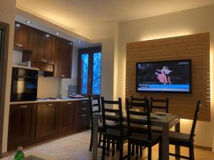 a kitchen with a table and a tv on a wall at Gran Baita Residence in Passo del Tonale