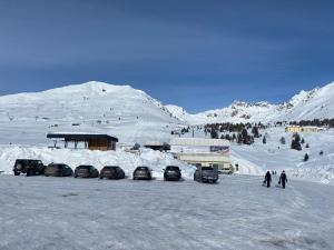 a group of cars parked in a parking lot in the snow at Gran Baita Residence in Passo del Tonale