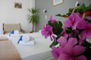 Pokój ze stołem z fioletowymi kwiatami w obiekcie George Apartments w mieście Livadia
