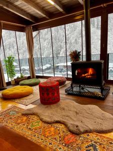 a living room with a fireplace and a room with a rug and a fireplace at Ayder Villa Babil in Ayder Yaylasi