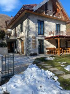 une maison avec de la neige devant elle dans l'établissement JOEN Village, à Librazhd