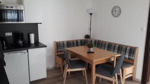 eine Küche mit einem Holztisch und Stühlen sowie einem Tisch und einer Theke in der Unterkunft Haus Linn in Ehrwald