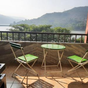 a table and two chairs on a balcony with a view at Lake View Lavish studio in Lavasa