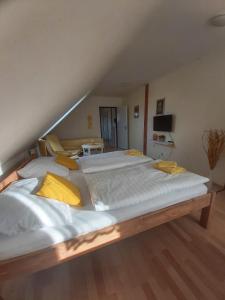 a large bed with white sheets and yellow pillows at Apartmány Pod Koulí in Domanín