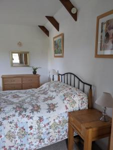 a bedroom with a bed and a wooden table at The Cottage, Little Trembroath in Stithians