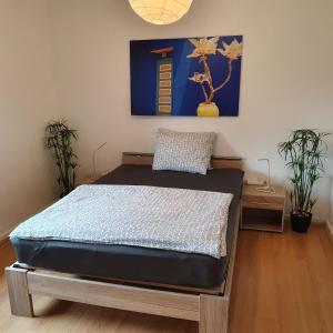 a bedroom with a bed in a room with plants at NiceRooms Aachen in Würselen