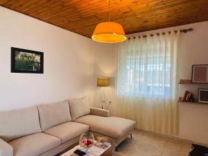 uma sala de estar com um sofá e uma janela em Mia Guest House - Entire home with balcony & garden em Divjakë