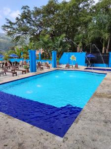 uma piscina no resort com cadeiras e guarda-sóis em Hotel Miami Beach San Jerónimo em San Jerónimo