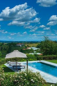 an umbrella and a swimming pool with a view at B&B Puntodivista in Chieri