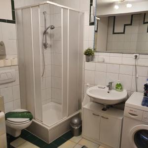 a bathroom with a shower and a toilet and a sink at NiceRooms Aachen in Würselen