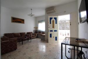 a living room with a couch and a door at Nice Holiday Apartment Hammam Sousse in Hammam Sousse