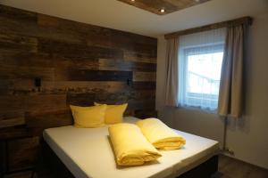 a bedroom with a bed with yellow pillows and a window at Apart&Chalet Chiara in Neustift im Stubaital