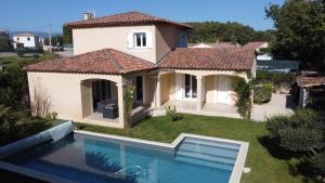 a villa with a swimming pool in front of a house at Villa Noa Pertuis in Pertuis