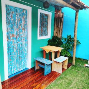 a house with a table and two benches on a deck at Pousada Hospedaria Nativus Caraiva in Caraíva
