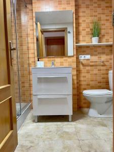 a bathroom with a sink and a toilet and a mirror at UIM Mediterraneo PB Felipe 2 Wifi in Puerto de Sagunto +7 photos