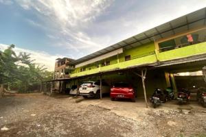 un edificio con coches estacionados frente a él en OYO 90847 Eko Guest House en Makassar