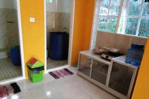 a kitchen with a counter and two windows in a room at OYO 90847 Eko Guest House in Makassar