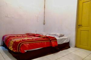 Un pat sau paturi într-o cameră la OYO 90847 Eko Guest House